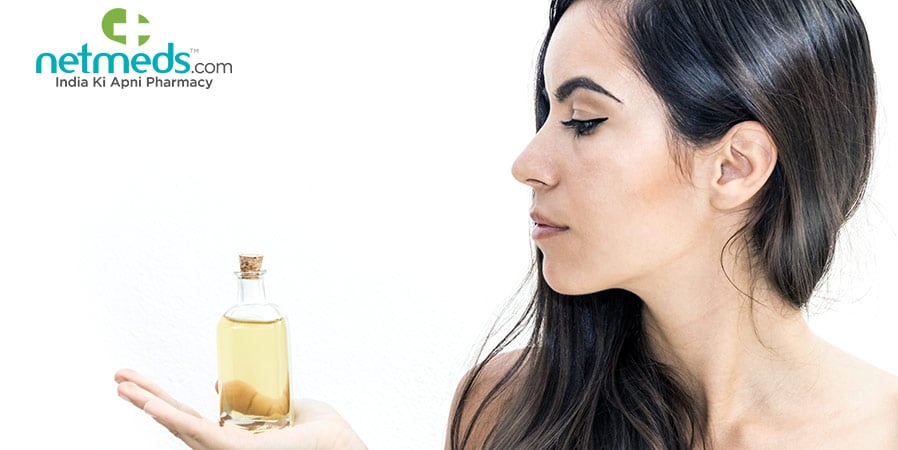 woman holding a castor oil bottle