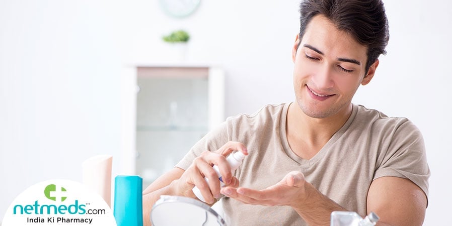Man using spray for skin care