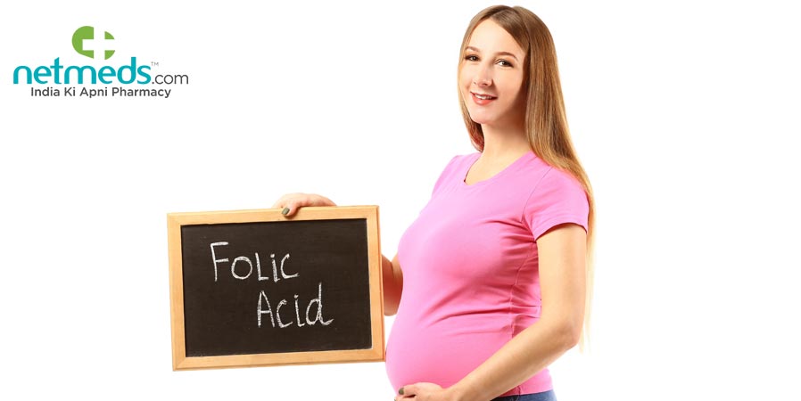 Pregnant woman with a folic acid board