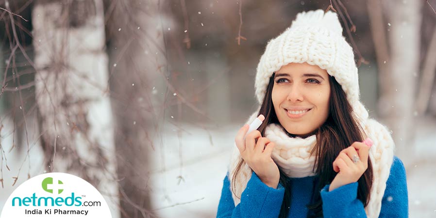 Woman applying lip balm in winter