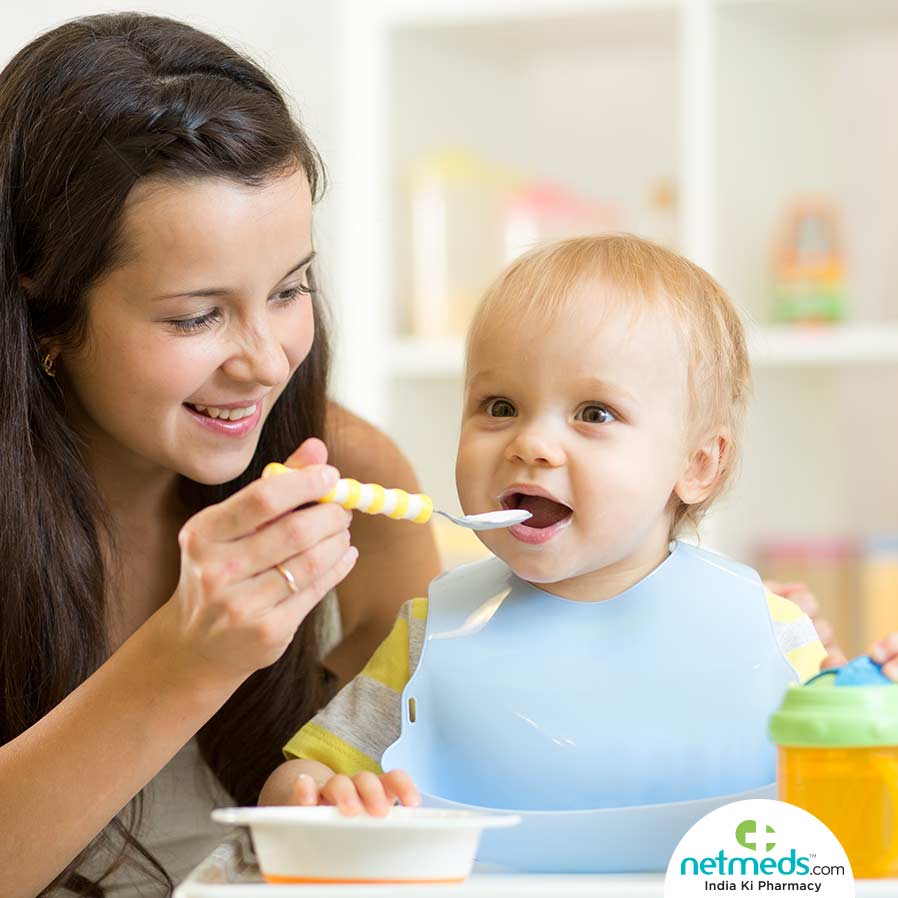 Mother feeding a baby with a spoon