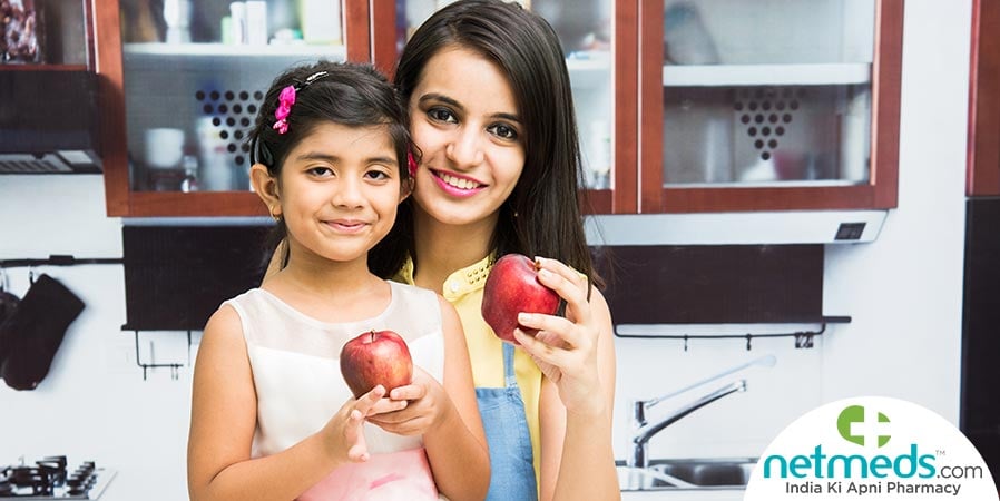Mom and daughter holding apples in their hands