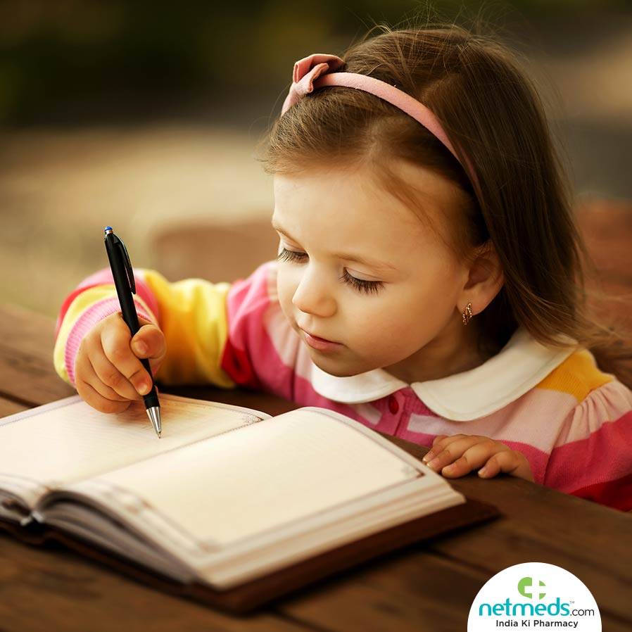A girl writing in a book with a pen